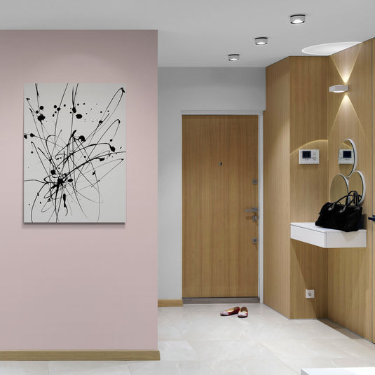 Pintura abstracta en blanco y negro con trazos y salpicaduras de tinta que crean un patrón dinámico y lleno de movimiento.