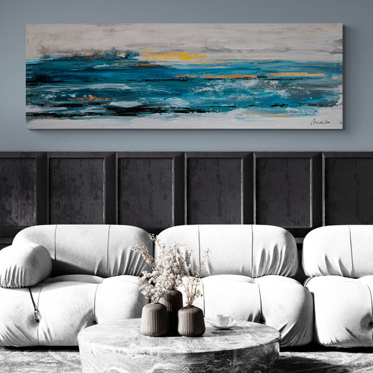 Cuadro de horizonte marino en tonos azules y amarillos sobre sofá blanco