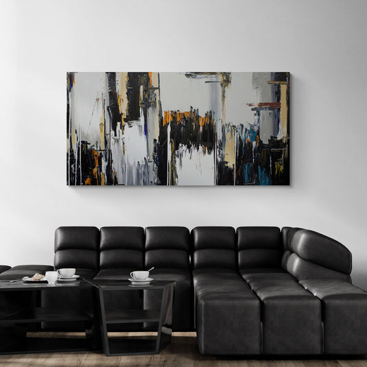 Cuadro abstracto con trazos en negro, oro y blanco sobre pared moderna