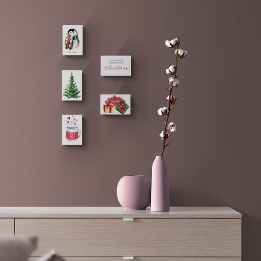 Conjunto de lienzos navideños con decoración minimalista en tonos suaves y jarrones rosas.