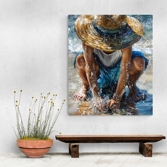 Cuadro de niño jugando en la playa con sombrero de paja