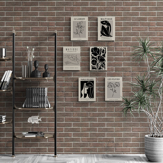 Set de cuadros decorativos minimalistas con ilustraciones botánicas y siluetas estilo Matisse y Picasso sobre pared de ladrillo