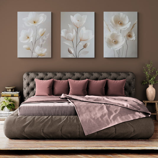Set de cuadros decorativos florales – Pinturas realistas de flores blancas sobre fondo neutro en dormitorio elegante con tonos tierra.