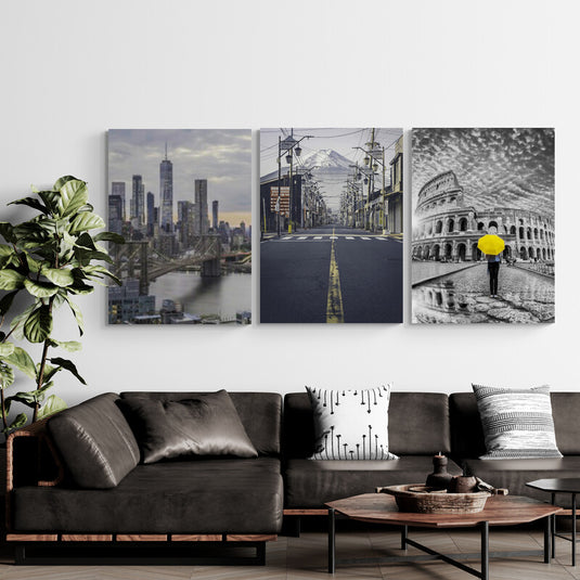 Tríptico decorativo de ciudades icónicas: Nueva York al atardecer, calle japonesa con vista al Monte Fuji y Roma en blanco y negro con paraguas amarillo destacado.