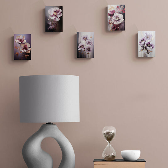 Conjunto de cuadros florales en tonos púrpuras y lilas sobre pared neutra