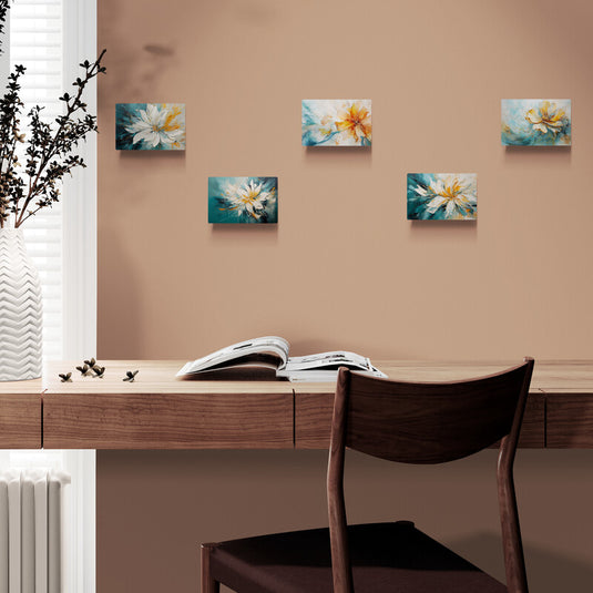 Conjunto de cuadros florales en tonos blancos, amarillos y turquesa sobre pared beige