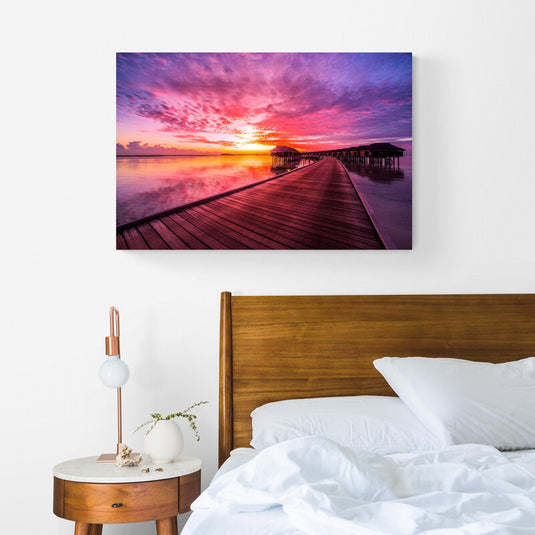 Vibrante fotografía de atardecer en muelle con cielo carmesí y cabañas sobre el agua