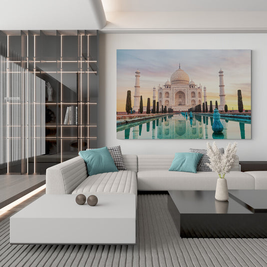 Taj Mahal reflejado en un estanque al amanecer con cielo en tonos pastel.