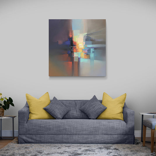 Pintura abstracta en tonos suaves de azul, naranja y violeta, colgada sobre un sofá gris.