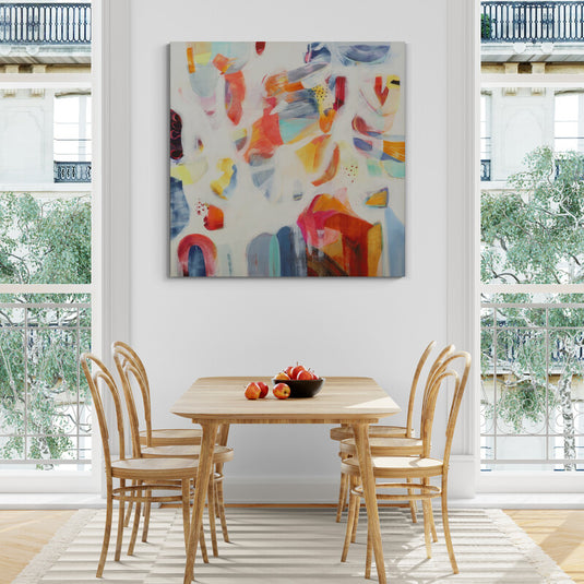 Pintura abstracta colorida sobre pared blanca en comedor luminoso