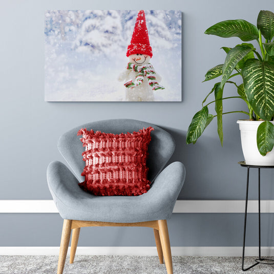 Muñeco de nieve con gorro rojo y bufanda en paisaje nevado