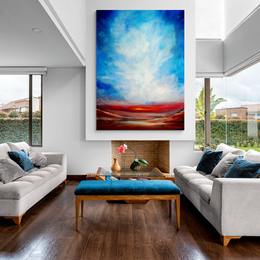 Cuadro de paisaje abstracto con cielo azul y horizonte rojo decorando una sala de estar moderna con chimenea.