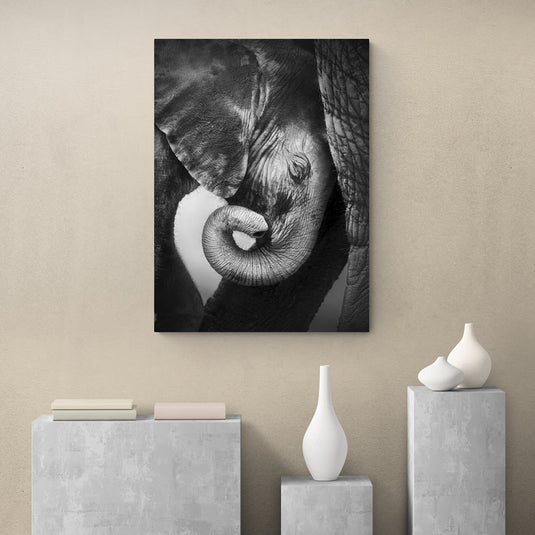 Fotografía en blanco y negro de un elefante y su cría en un momento tierno.