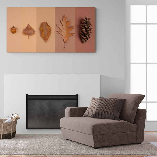 Cuadro decorativo de elementos otoñales con gradación de colores, mostrando bellota, hojas secas y piña sobre fondo rosa a marrón