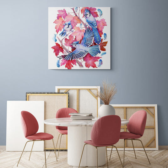Cuadro decorativo de aves azules sobre ramas con hojas en tonos rojos pastel y rosa en fondo blanco