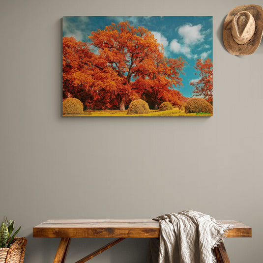 Paisaje otoñal con árboles de hojas naranjas, pequeños arbustos y césped verde.