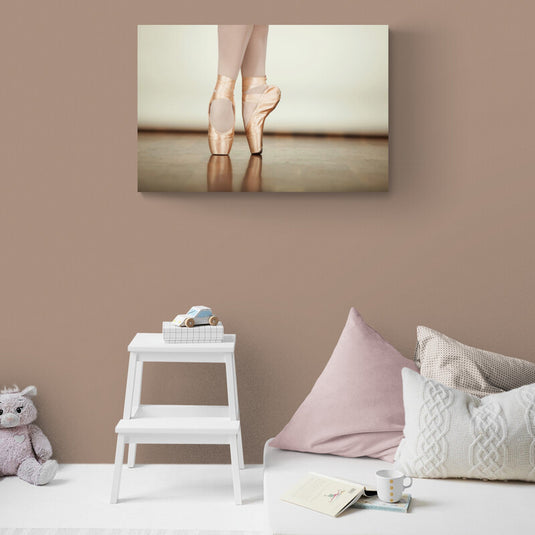 Primer plano de zapatillas de ballet en punta en tonos pasteles sobre piso de madera, simbolizando la danza clásica