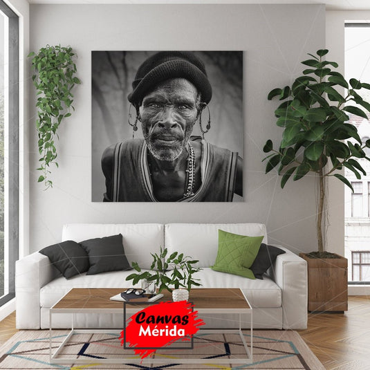 Retrato monocromático de hombre mayor con pendientes tradicionales y mirada expresiva