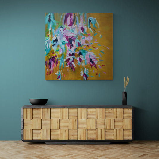 Pintura abstracta con colores vibrantes que representan flores imaginarias en tonos de azul, rosa y blanco sobre fondo dorado.