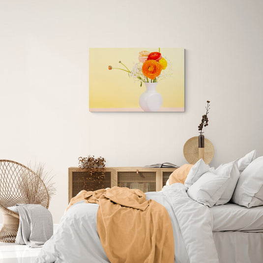 Fotografía de ranúnculos coloridos y gypsophila en jarrón de porcelana sobre fondo degradado amarillo a rosa.