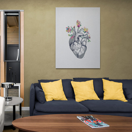 Ilustración detallada de un corazón humano con flores coloridas emergiendo de su interior sobre un fondo neutro