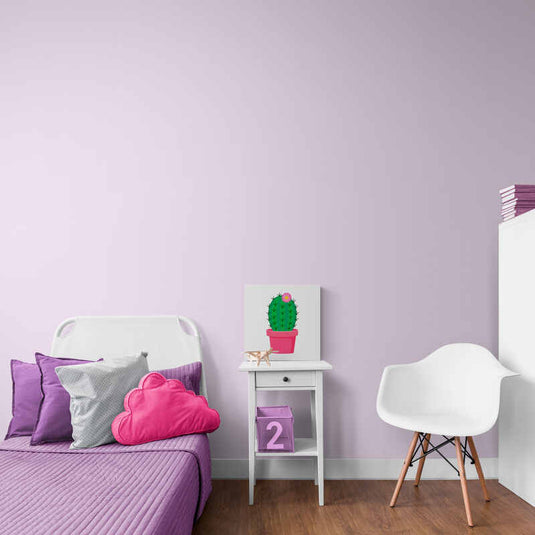 Cactus verde con flor rosa en maceta fucsia sobre fondo blanco