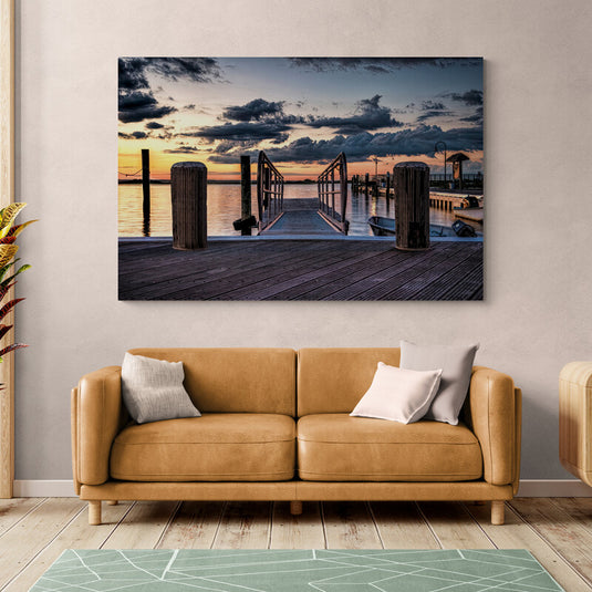 Fotografía de muelle de madera al ocaso con nubes dramáticas y luz cálida