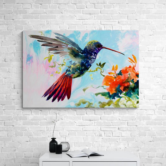 Colibrí multicolor sobre fondo azul, rosa y blanco junto a flores naranjas con acentos verdes