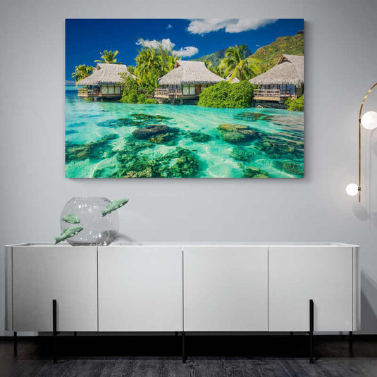 Cabañas sobre el agua turquesa con arrecifes de coral y vegetación tropical