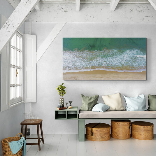 Vista aérea de olas verdes y espumosas encontrando la arena en la playa.