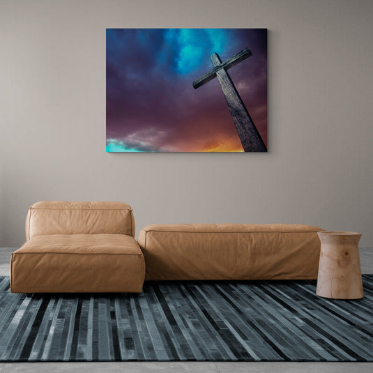 Cruz de madera bajo un cielo dramático con luces y sombras.