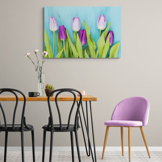 Fotografía de tulipanes lilas y violetas contra fondo azul.