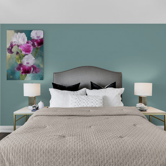 Pintura de lirios iris con pétalos blancos y morados sobre fondo azul.