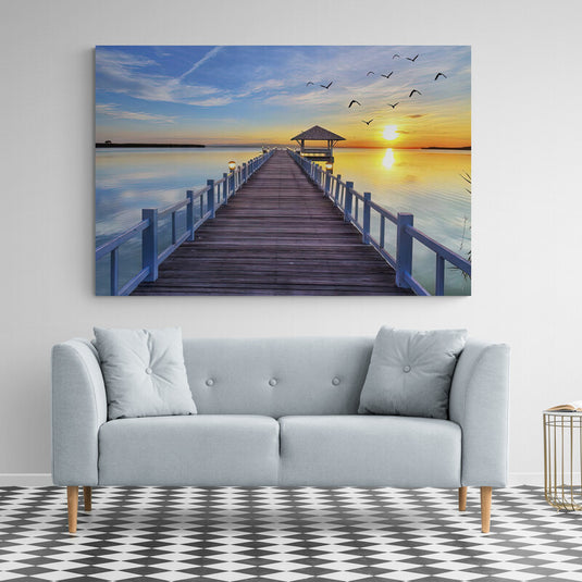 Fotografía de muelle hacia mirador con aves volando al amanecer en lago tranquilo"