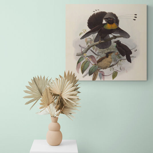 Faisanes en colores negro y amarillo entre ramas con hojas verdes y rosas sobre fondo beige en cuadro decorativo