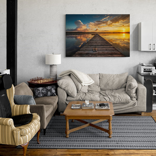 Fotografía de atardecer en muelle con un par de zapatos, cielo reflejado en agua calma