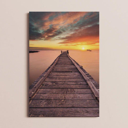 Fotografía de un muelle de madera al amanecer con cielo colorido
