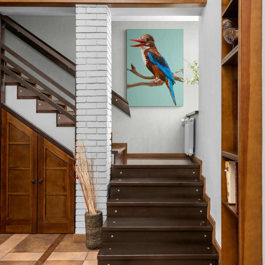 Cuadro decorativo con pájaro en tonos blancos, azules y cafés, sobre ramas café en fondo turquesa claro.