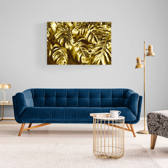 Hojas de Monstera deliciosa doradas en composición opulenta y tropical