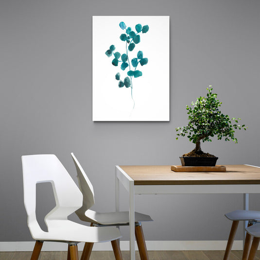 Cuadro decorativo con fondo blanco y destacada ramita de hojas verdes.