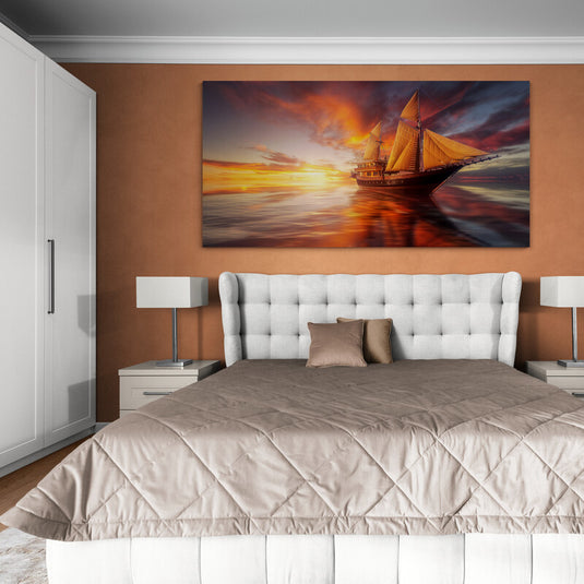 Fotografía dramática de un velero al atardecer con cielo y mar en tonos rojizos