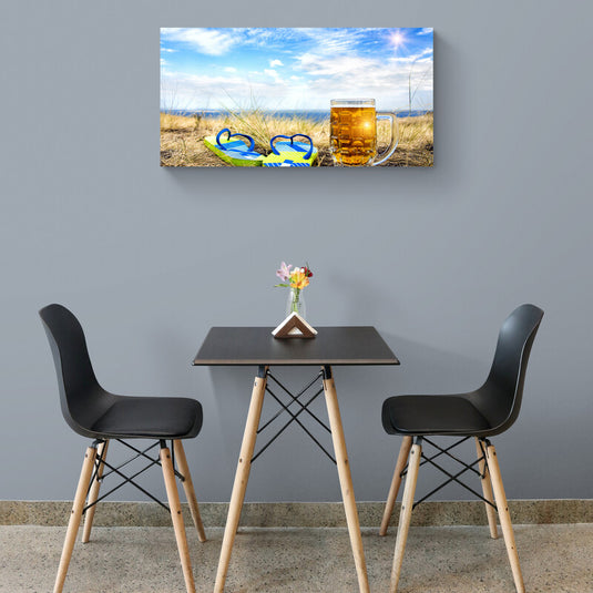 Jarra de cerveza fría y chanclas en la arena con cielo despejado en el fondo