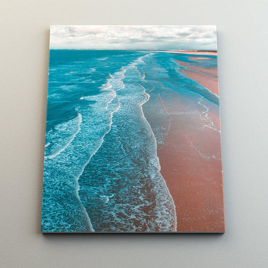 Fotografía aérea de la orilla del mar mostrando la división entre agua azul y arena