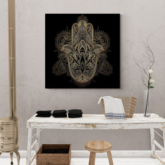 Mano de Hamsa dorada con patrones ornamentales en fondo negro.