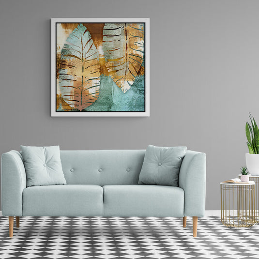 Cuadro decorativo con marialuisa blanca enmarcando diseño de hojas en tonos turquesa, cobre y blanco.