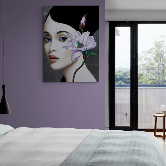 Rostro femenino en fondo gris con cabello negro y flor lila decorativa