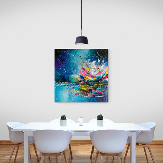 Cuadro abstracto de flor de loto en colores vibrantes decorando un comedor moderno con mesa blanca.