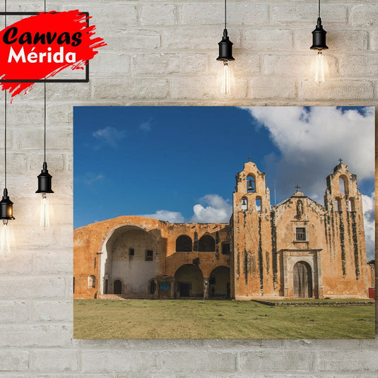 Fotografía de la iglesia colonial de Maní, Yucatán, con campanarios y paredes de adobe bajo un cielo azul.