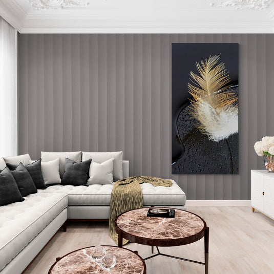 Pluma dorada y blanca sobre superficie negra con gotas de agua