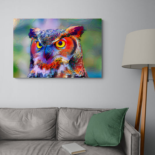 Búho fosforescente en tonos naranja, amarillo, azul, morado y rojo, centrado contra un fondo desenfocado de verdes, lilas y azules.